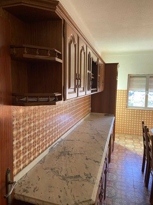 Cozinha ampla com armários e bancadas dos dois lados