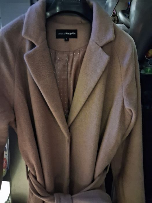 beżowy płaszcz z paskiem marki KappAhl.
