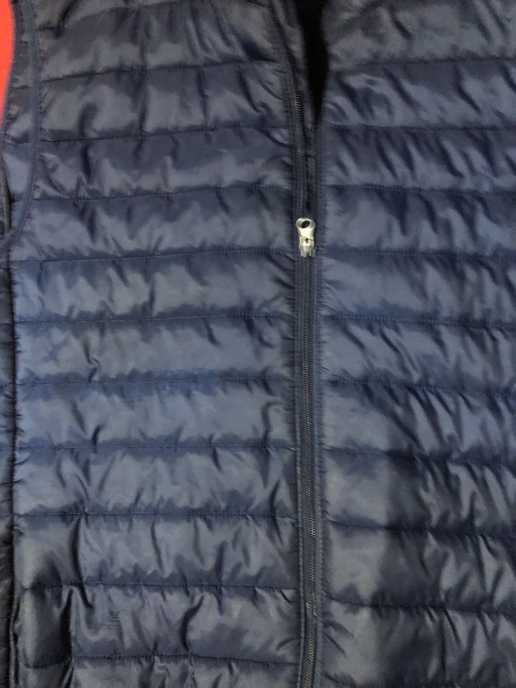 Colete almofadado, com bolsos latetais e fecho inteiro