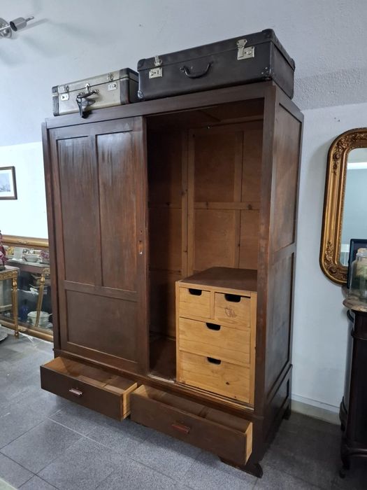 Roupeiro em madeira maciça com portas de correr.