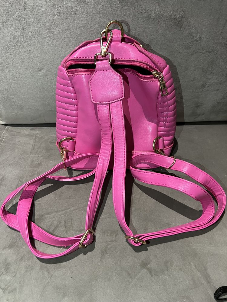 Mochila fúcsia/rosa com formato de blusão com metais dourados