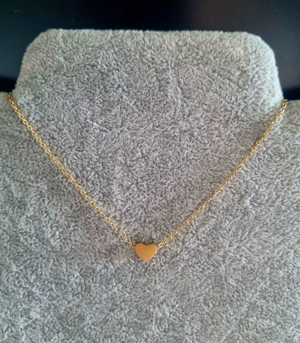 Colar dourado, em aço, com pequeno coração fixo. Tem extensor