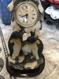 Relógio com estátua de pinguins