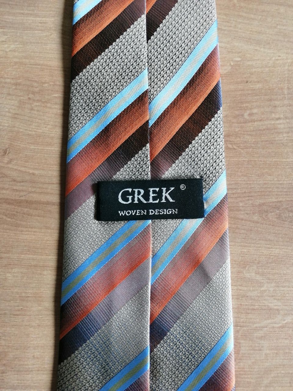 Krawat w paski w kolorach :brąz, pomarańcz, niebieski, złoto Grek