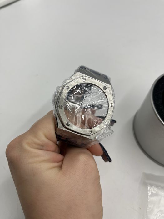 Nowa obudowa do zegarka zapakowana w metalowe pudełko.