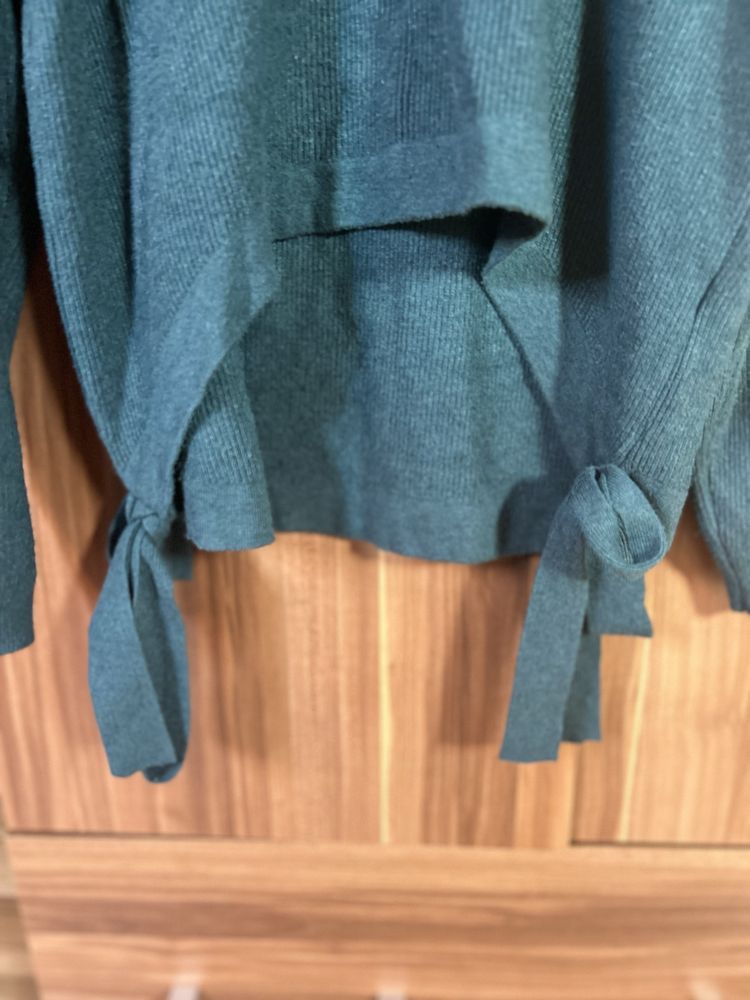 Zielony sweter z krótszym przodem i wiązaniami po bokach