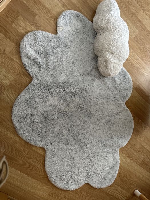 Tapete formato nuvem azul com almofada branca