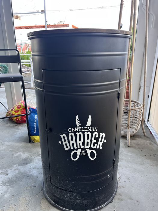 Barril preto com acabamento em madeira.