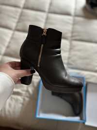 Botas pretas com fecho dourado