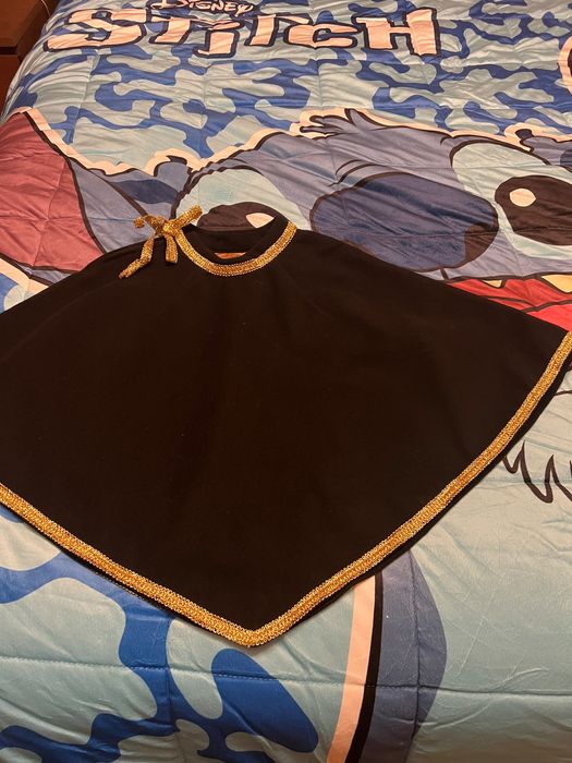 Capa em fazenda preta com fita dourada, de criança