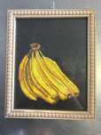 Cacho de bananas pintadas em fundo preto