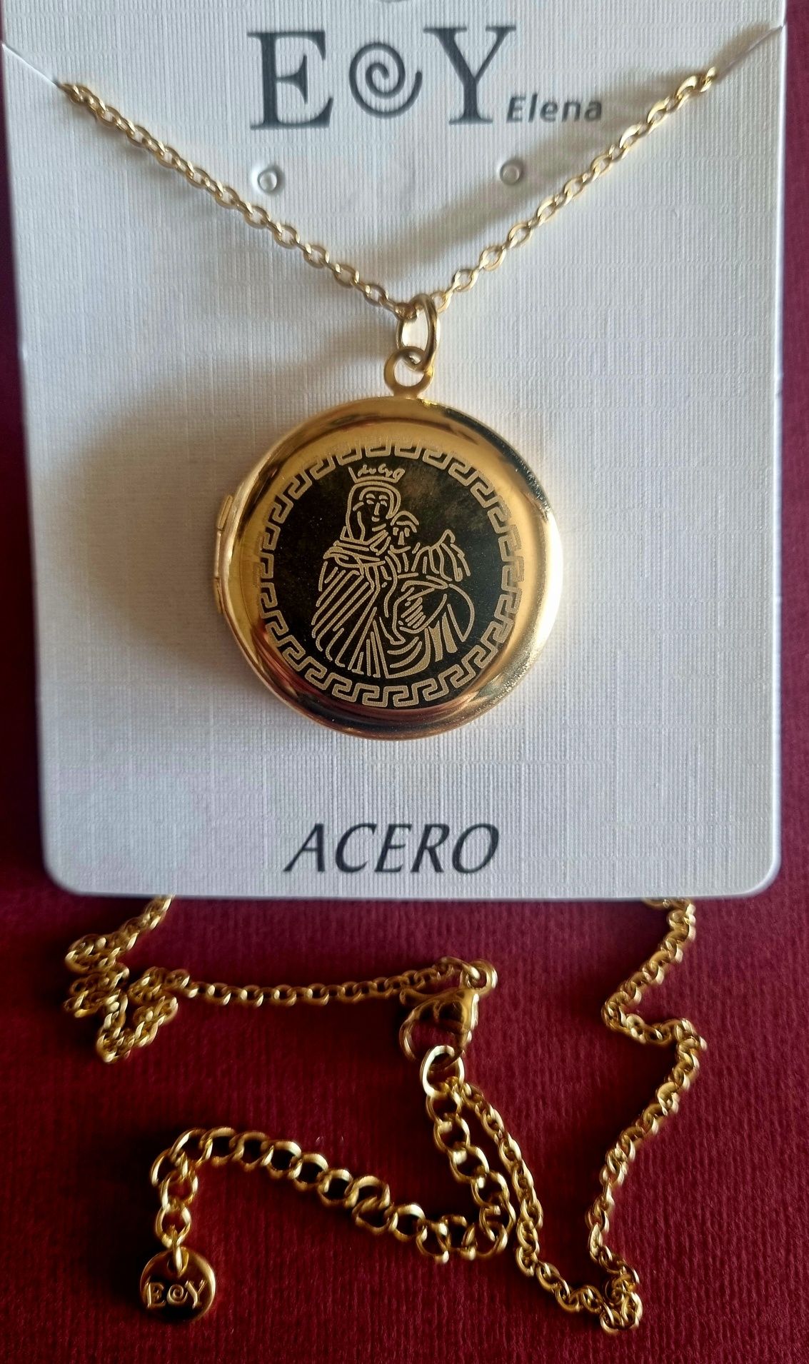 Colar/relicário dourado, em aço, com a Nossa Senhora. Tem extensor