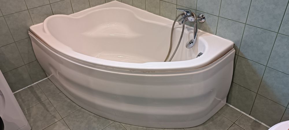 Wanna narożna z siedziskiem obudową oraz stelażem.