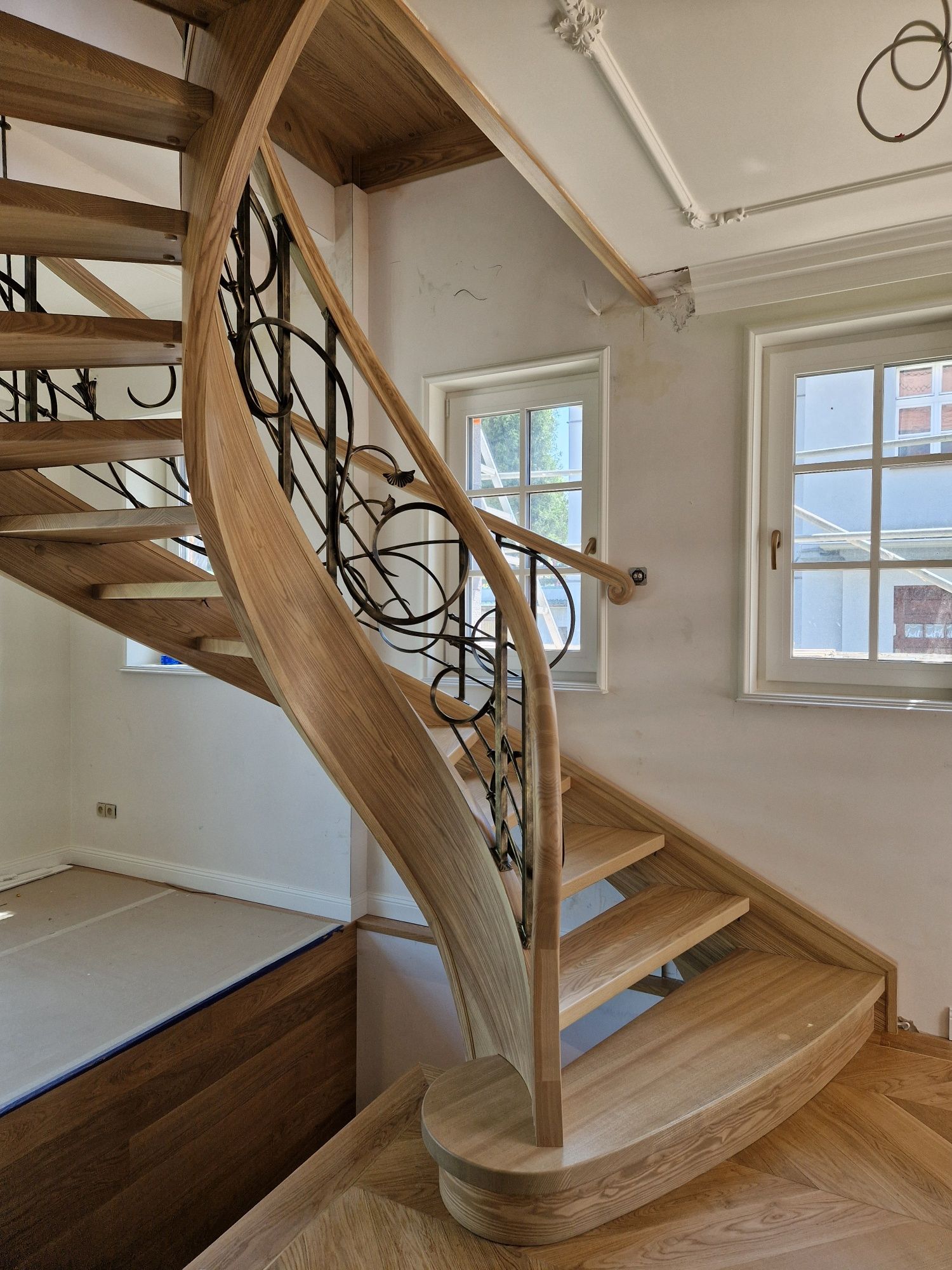 Schody gięte drewniane kręcone kute balustrady