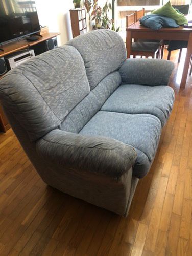 1 sofá azul, bastante usado