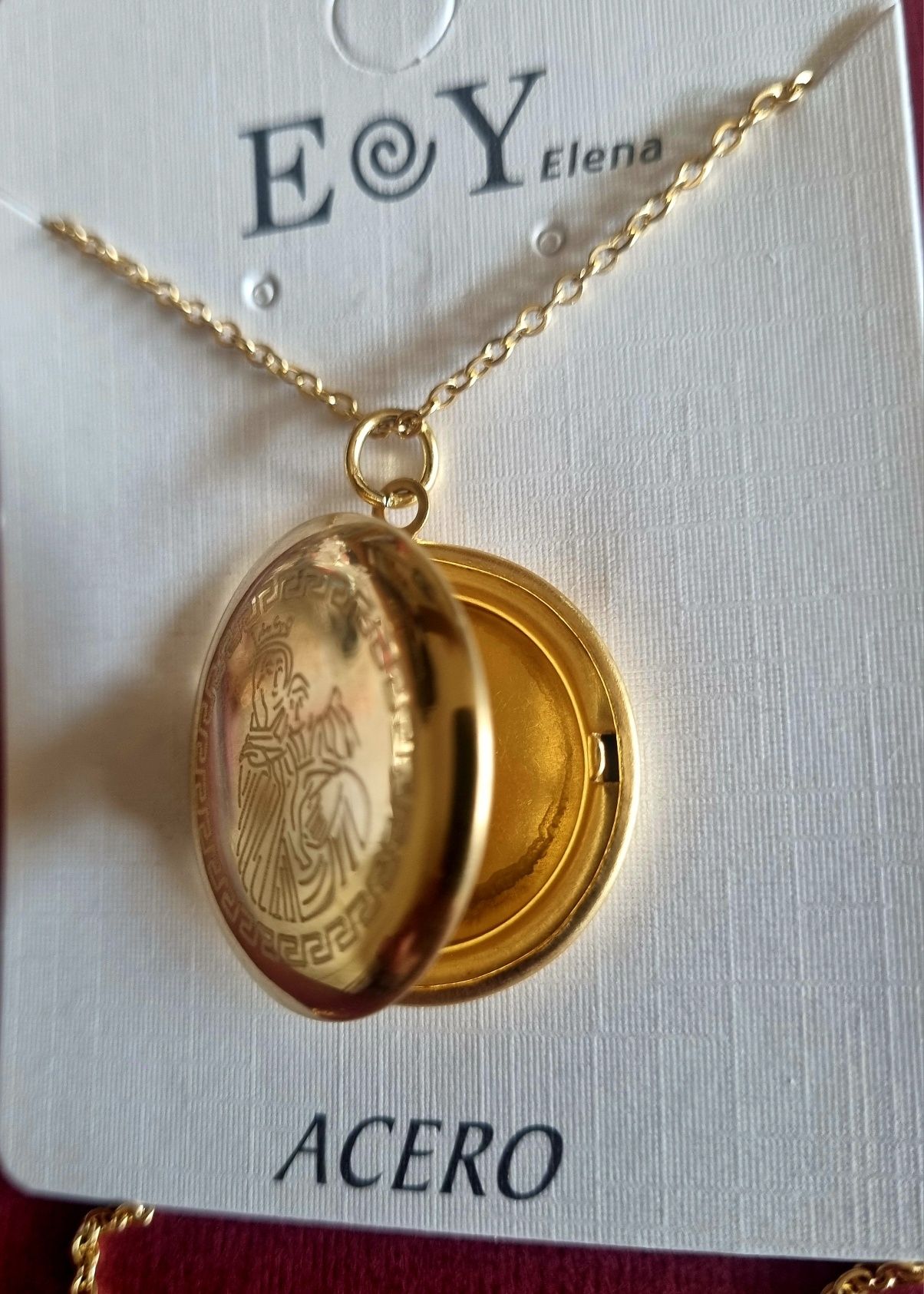 Colar/relicário dourado, em aço, com a Nossa Senhora. Tem extensor