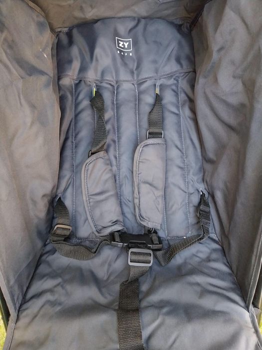 Carrinho de bebê com capa de chuva da marca Zippy.