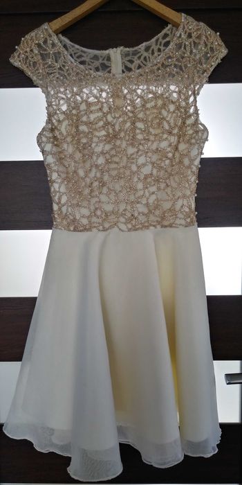 Sukienka ozdabiana perełkami w kolorze ecru.