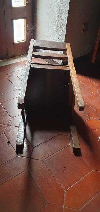Cadeira antiga em madeira maciça, resistente e estável.