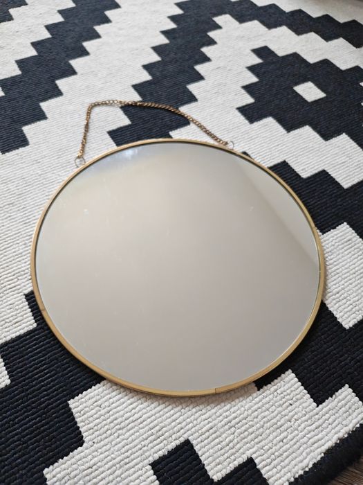 Lustro na łancuszku w ramie o złotym kolorze