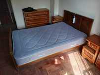 Quarto casal com cama, duas mesinhas cabeceira, uma cómoda e roupeiro.