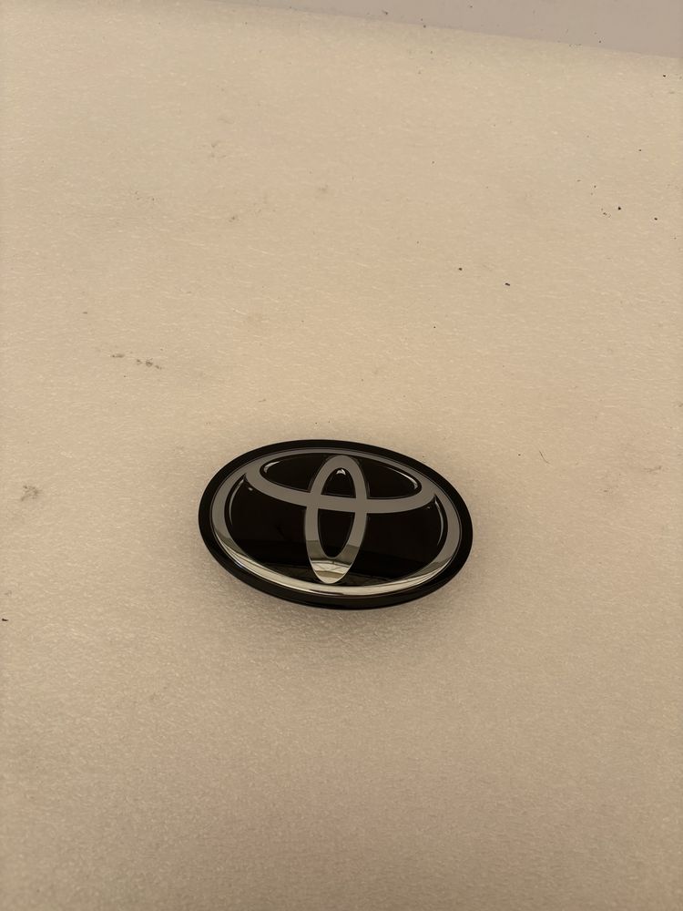 Toyota Corolla E21 sedan emblemat znaczek logo przód pod radar grilla