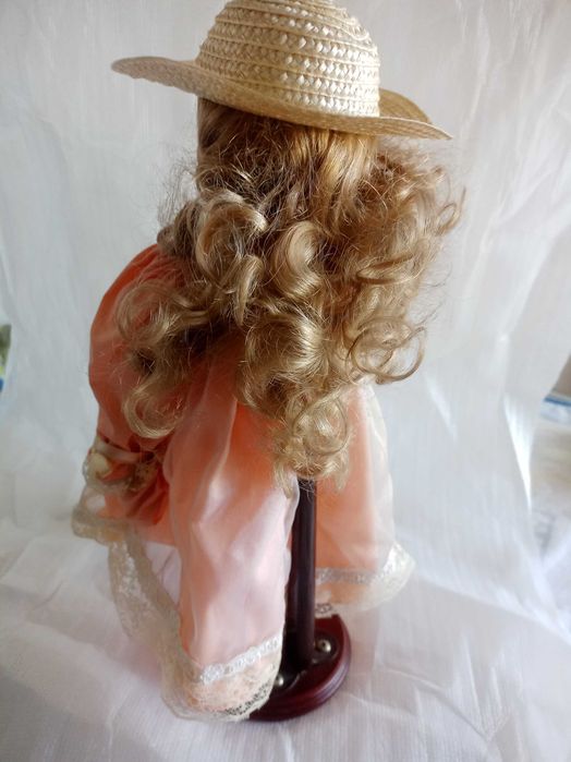 Boneca grande de porcelana, com suporte de madeira