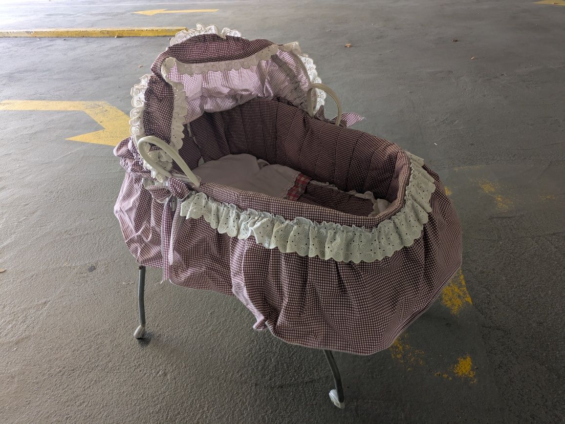 Alcofa antiga com suporte e roupa