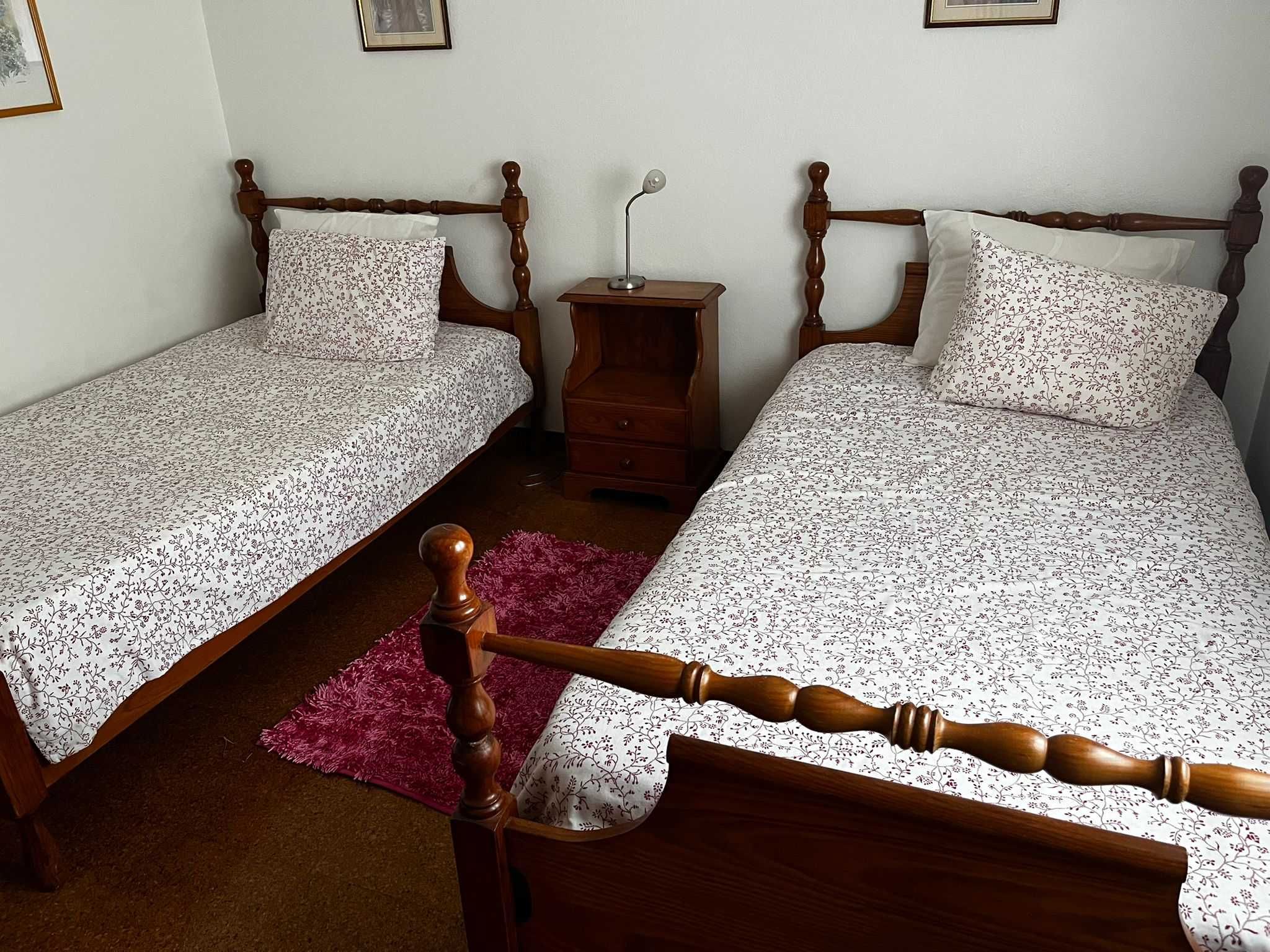 Camas de Madeira com colchões e mesa de cabeceira