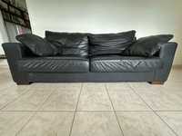 Sofa em pele, de cor preto com duas almofadas