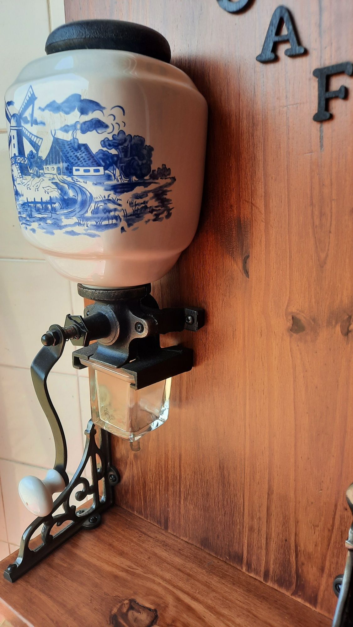 Moinho manual de café com suporte em madeira.