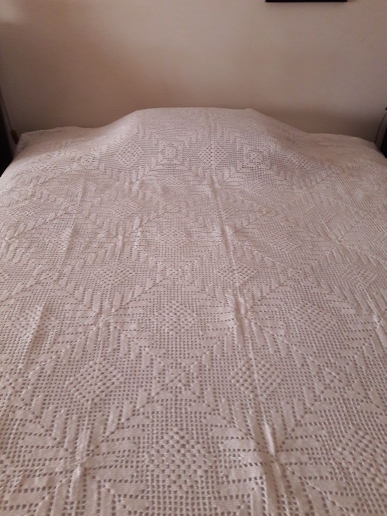 Colcha em renda feita à mão para cama de solteiro.