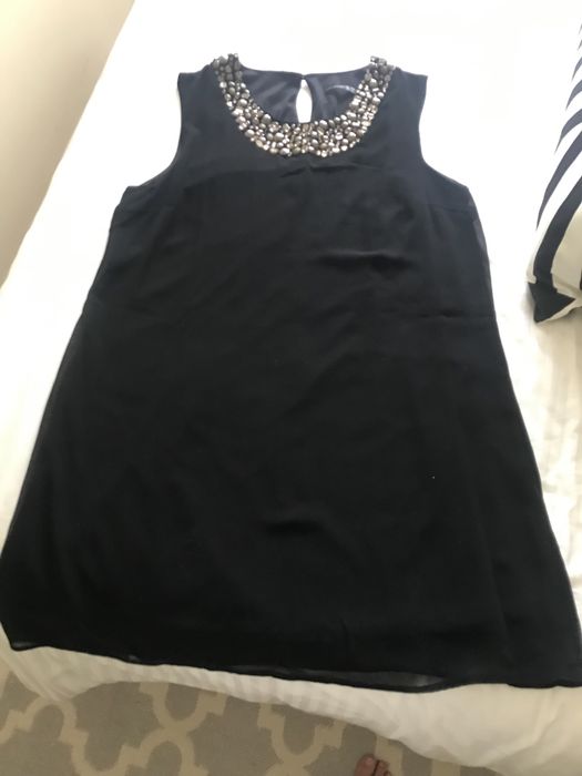 Vestido preto de festa com adornos como colar
