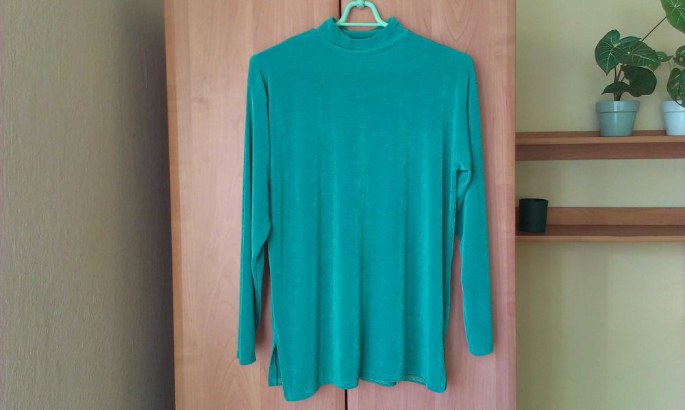 Turkusowa bluzka z długim rękawem.