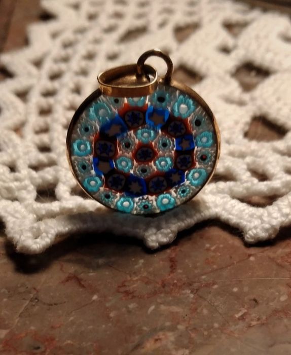 Medalha de prata dourada contrastada com vitral