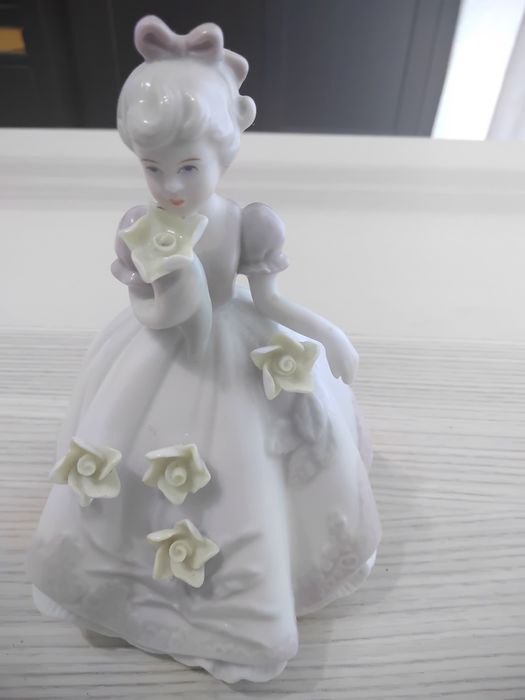 A estatueta de porcelana.