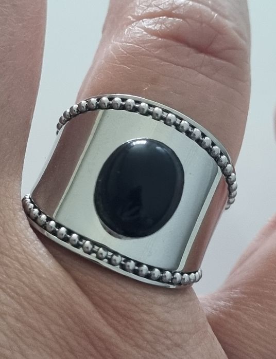 Anel prateado, em aço  com pedra preta oval. Ajustável