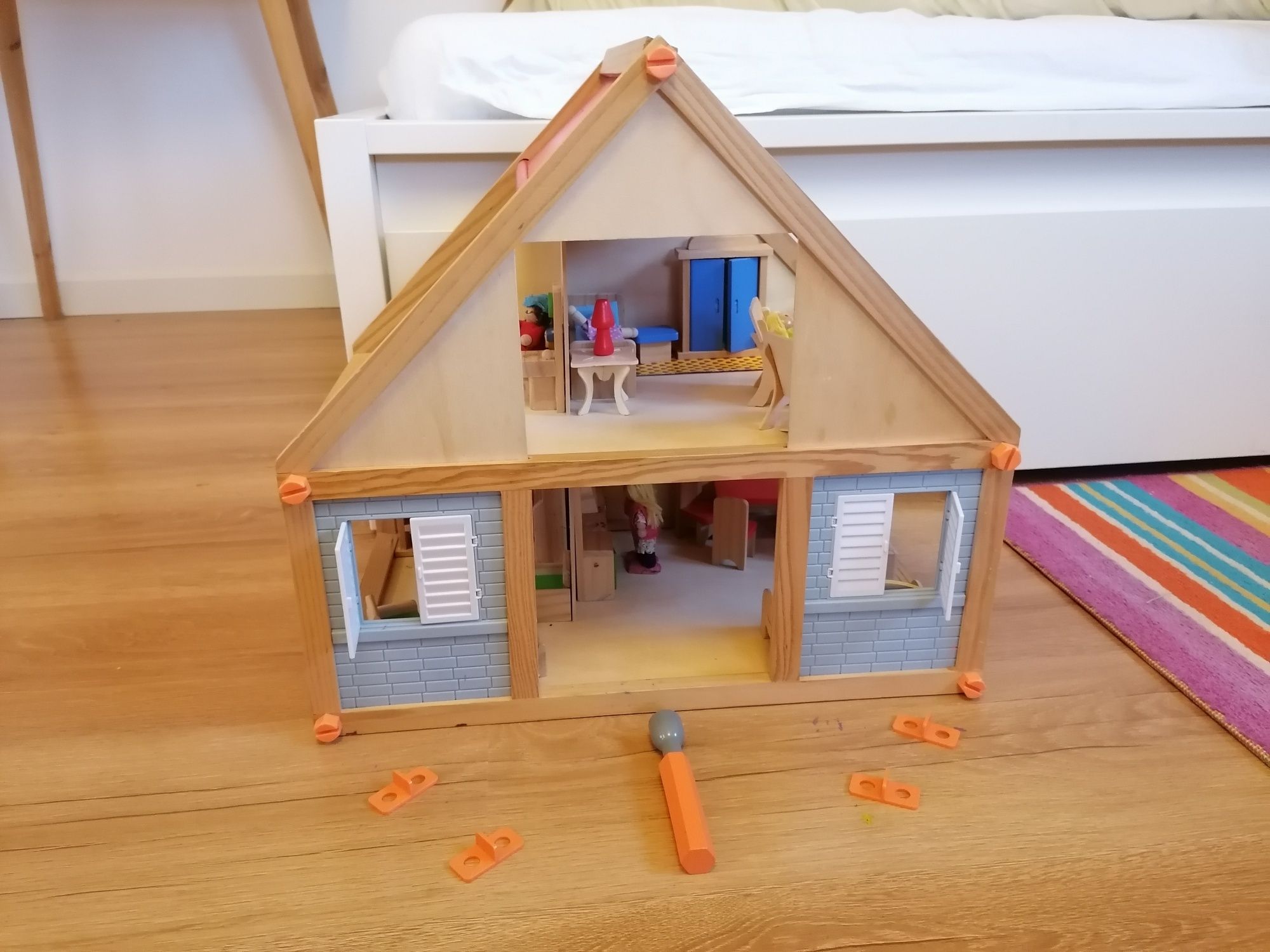 Drewniany domek dla lalek z mebelkami i lalkami