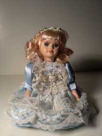 Piękna lalka porcelanowa, siedząca