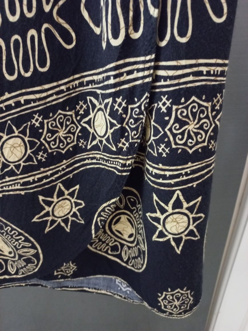 Saia comprida preta, trespassada, com motivos dourados