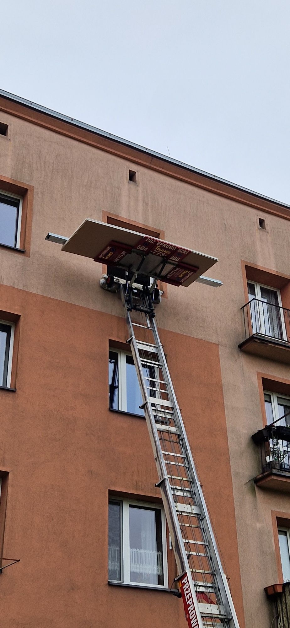 Gruz materiały budowlane oknem balkonem.