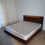 Cama com colchão e mesa de cabeceira