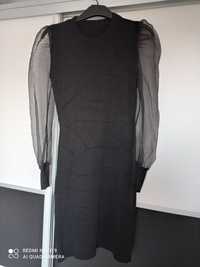 Czarna sukienka z tiulowanymi rękawami.