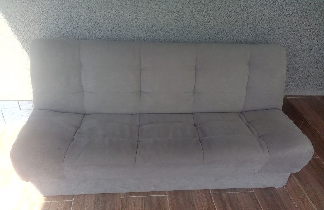 Szara sofa kanapa z funkcją spania i schowkiem na pościel