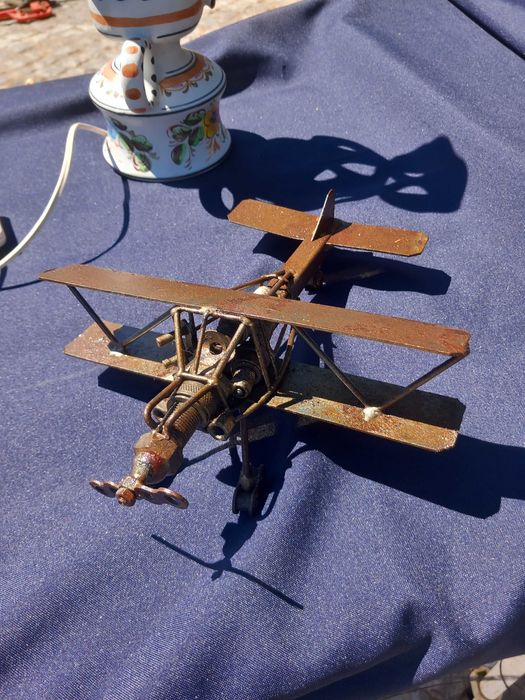 Escultura de um biplano feita de metal reciclado