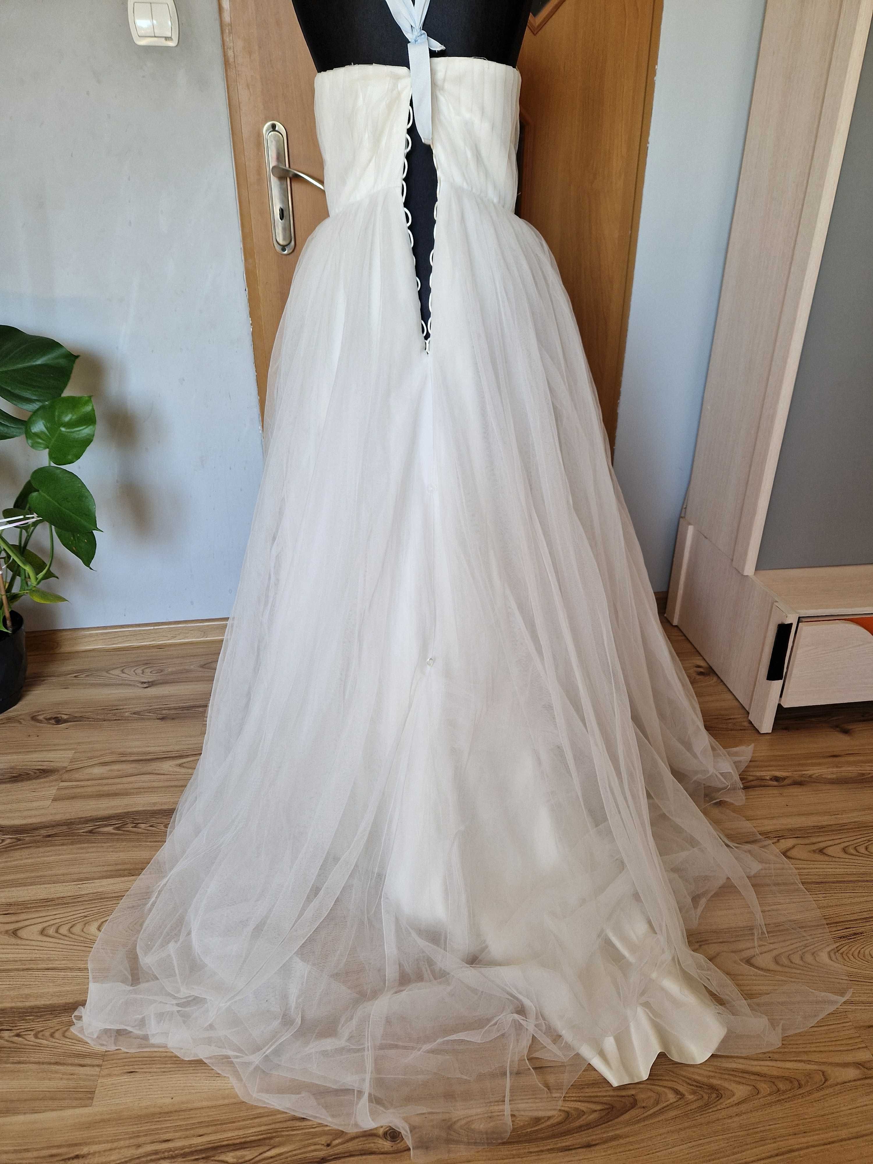 Biała suknia ślubna rozkloszowana z tiulem i zdobieniami