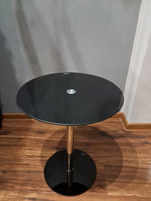 mały okrągły stolik z czarnym szklanym blatem