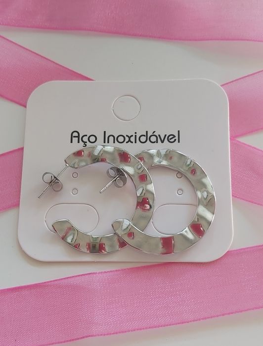 Argolas prateadas, em aço, finas e leves.