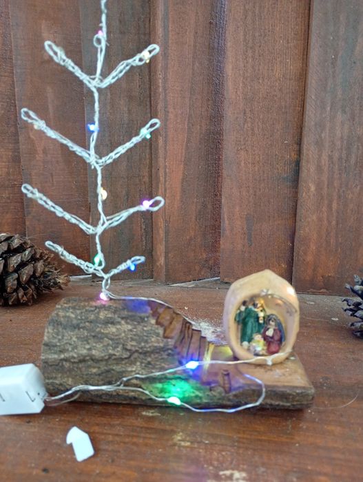 Troco de carvalho com árvore de Natal e sagrada família