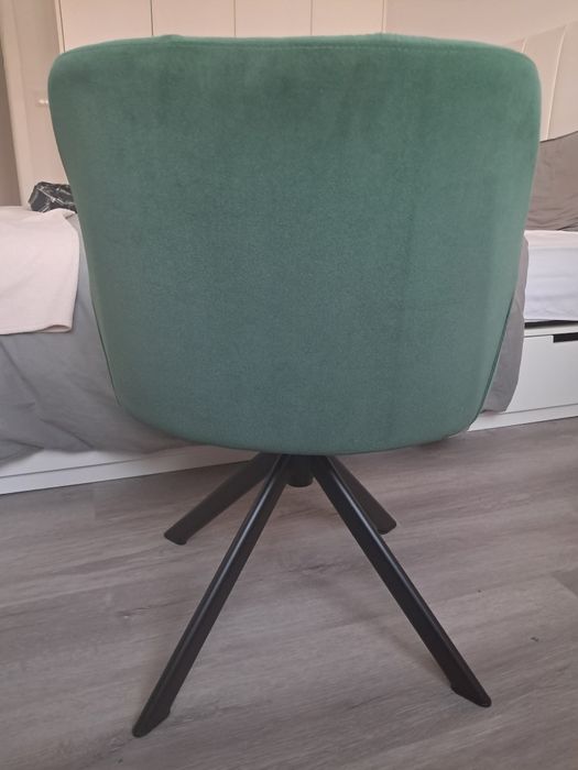 Cadeira giratória verde com pernas de aço preto.